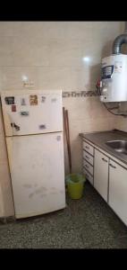 een keuken met een witte koelkast en een spoelbak bij PH en Mar de Ajó Centro in Mar de Ajó