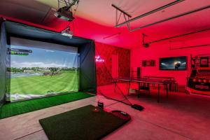 a room with a ping pong table in a room with red lights at Desert Oasis: Pool, Spa, Golf Sim + EV Charger in Bermuda Dunes