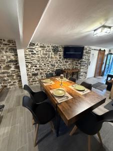 una sala da pranzo con tavolo in legno e sedie nere di Stone house seta a Séta
