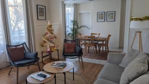 a living room with a christmas tree and a couch at Villa des roses, comme à la maison in Cherbourg en Cotentin