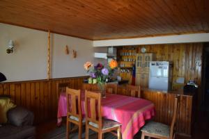 eine Küche mit einem Tisch mit einer Vase mit Blumen darauf in der Unterkunft Acogedora Casa Familiar in Pichilemu + 15 Fotos
