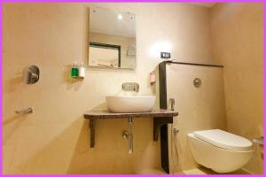 um banheiro com uma pia, um vaso sanitário e um espelho em SEA VIEW from rooftop- SWIMMING POOL Hotel NBR Near Jagannath Temple And Sea Beach - Parking- Spa With Restaurant - Fully Air Conditioning Deluxe Rooms - Prime Location em Puri