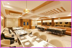 um restaurante com mesas e cadeiras em uma sala em SEA VIEW from rooftop- SWIMMING POOL Hotel NBR Near Jagannath Temple And Sea Beach - Parking- Spa With Restaurant - Fully Air Conditioning Deluxe Rooms - Prime Location em Puri