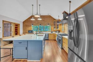 a kitchen with blue cabinets and a refrigerator at Gorgeous Lakefront Escape - New Renovations in Mineral