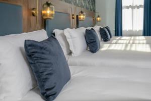 een slaapkamer met drie witte bedden met kussens bij القاهرة العبور الحي التاسع in Obour