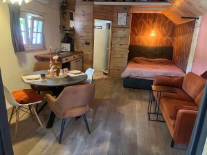 a room with a table and a bed and a kitchen at Het Houten Huis in Hierden