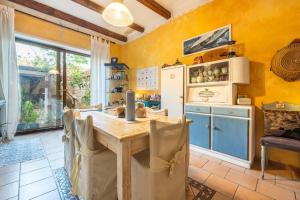 Una cocina con una mesa de madera y un refrigerador. en Domus de Janas Rooms Gonnesa, en Gonnesa