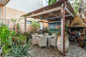 un patio con una mesa y sillas y una motocicleta en Domus de Janas Rooms Gonnesa, en Gonnesa