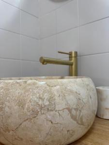 een grote stenen wastafel in een badkamer met een kraan bij Ti Paradis Doré in Schœlcher