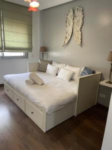 una cama blanca con almohadas en una habitación en Magnifique Appartement familial avec piscine, en Mohammedia 5 fotos más