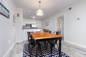 a kitchen and dining room with a wooden table and chairs at Beachfront Condo with Ocean Views and Pool Access in Croatan Shores