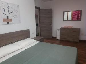 Apartamento Sole e Luna في مارتينسيكورو: غرفة نوم فيها سرير وخزانة