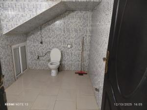 a bathroom with a toilet in a tiled wall at Studio riad zitouna in Meknès