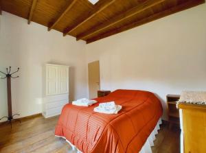 een slaapkamer met een bed met twee handdoeken erop bij Los Fresnitos in Villa Lía