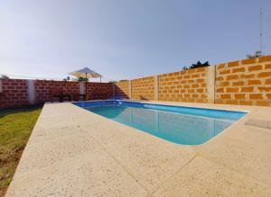 een zwembad voor een bakstenen muur bij Los Fresnitos in Villa Lía +3 foto's