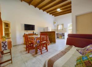een woonkamer met een tafel, stoelen en een televisie bij Los Fresnitos in Villa Lía