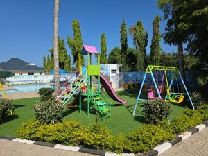 ein Spielplatz in einem Park mit Rutsche und Schaukeln in der Unterkunft The Hidden Paradise in Mombasa