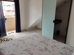 een slaapkamer met een bed met een bloemenbed bij Suíte 4 Centro de São Thomé das Letras in São Thomé das Letras