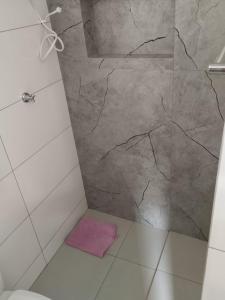 een badkamer met een marmeren douche en een roze vloerkleed bij Suíte 4 Centro de São Thomé das Letras in São Thomé das Letras