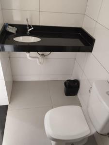 een badkamer met een wit toilet en een wastafel bij Suíte 4 Centro de São Thomé das Letras in São Thomé das Letras
