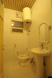 un baño con inodoro y lavabo en منازل الحساء للشقق الفندقية, en Al Hofuf 17 fotos más