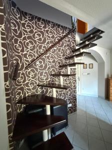 a staircase in a room with a patterned wall at Gyékény Pihenő in Szarvas