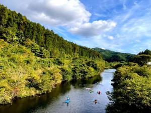 a group of people are canoeing down a river at Lien Tono in Tōno