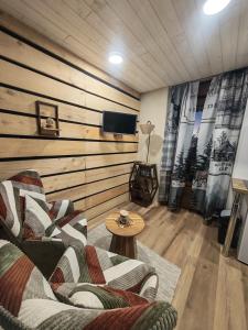 a living room with a couch and a table at Studio Stylisé Chalet in Rochejean