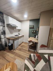 a living room with a kitchen and a table at Studio Stylisé Chalet in Rochejean