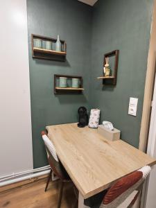 a wooden table in a room with a green wall at Studio Stylisé Chalet in Rochejean