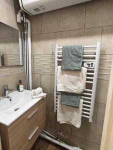 ein Badezimmer mit Waschbecken, Spiegel und Handtüchern in der Unterkunft Studio Stylisé Chalet in Rochejean