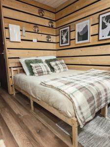 ein Schlafzimmer mit einem Bett in einer Holzwand in der Unterkunft Studio Stylisé Chalet in Rochejean + 7 Fotos