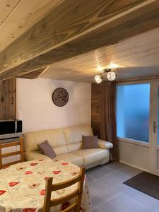 una sala de estar con un sofá y una mesa en L'atelier de l'horloger, 1 à 4 personnes, en Maîche