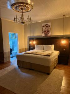 Sazeesha Apartments في ندولا: غرفة نوم بسرير وثريا