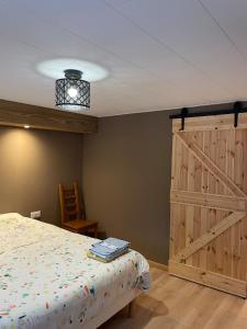 1 dormitorio con 1 cama y puerta de madera grande en L'atelier de l'horloger, 1 à 4 personnes, en Maîche 16 fotos más