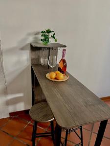 een houten tafel met een bord met sinaasappels en wijnglazen bij My Home in Milaan