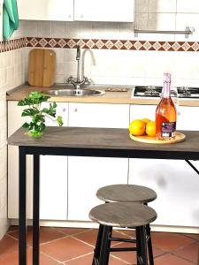 een keukenaanrecht met twee krukken en een fles alcohol bij My Home in Milaan +5 foto's