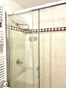 een douche met een glazen deur in een badkamer bij My Home in Milaan