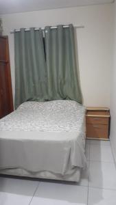 een slaapkamer met een bed met een groen gordijn bij Cantinho da paz in Gravatá +4 foto's