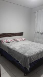 een bed in een witte kamer met een raam bij Cantinho da paz in Gravatá