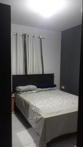 een slaapkamer met een bed met een wit dekbed bij Cantinho da paz in Gravatá