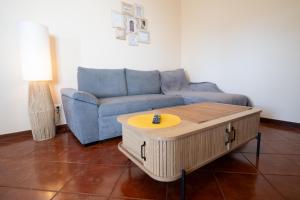 a living room with a blue couch and a coffee table at Ferienhaus Treibholz in Funchal