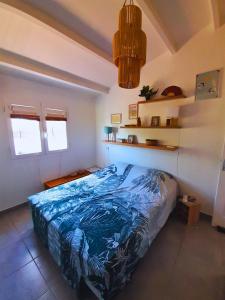 a bedroom with a bed with a blue comforter at Villa La Kaz a Gwada in Port-Louis