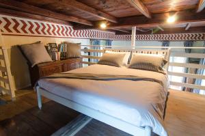 um quarto com uma cama branca e um tecto de madeira em B&B Chocolat au lac em Omegna