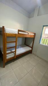 een houten stapelbed in een kamer met een raam bij Nunes stay in Prado