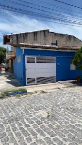 een blauw gebouw met een garagedeur aan een straat bij Nunes stay in Prado
