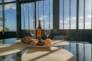 a table with a plate of food and wine glasses at Ferienhaus Treibholz in Funchal +8 photos