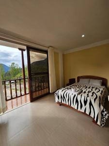 1 dormitorio con cama con estampado de cebra y balcón en Puente de Gocta, en Cocachimba