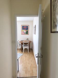 einen Flur mit einem Tisch und einem Esszimmer in der Unterkunft T2 PLEIN CENTRE - 100m marché LA BAULE in La Baule