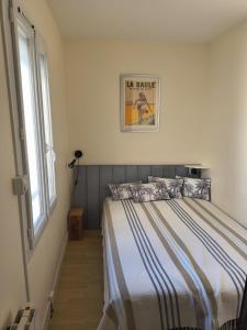 ein Schlafzimmer mit einem Bett und einem Bild an der Wand in der Unterkunft T2 PLEIN CENTRE - 100m marché LA BAULE in La Baule